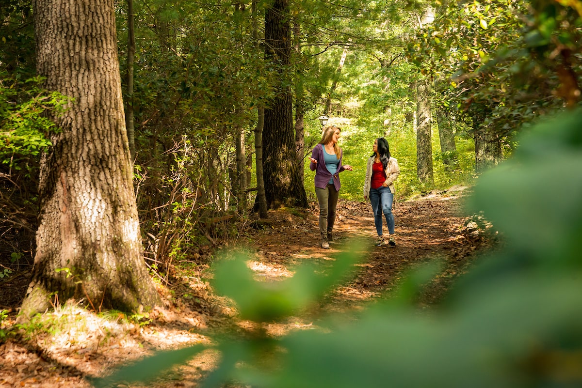 Two woman walking together on a nature path at the Ridge Recovery Center.