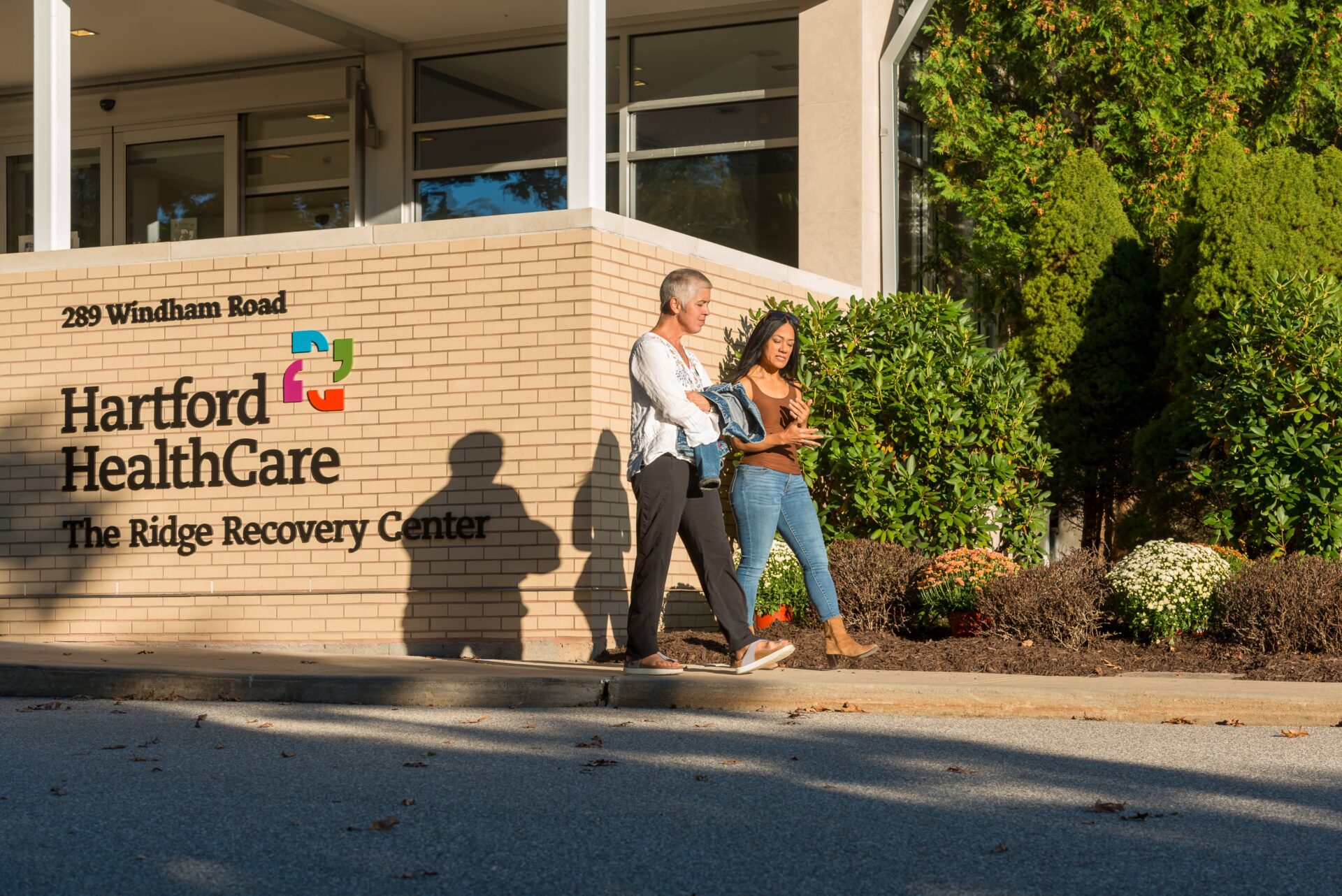 Two women walking in front of the Ridge Recovery Center sign.