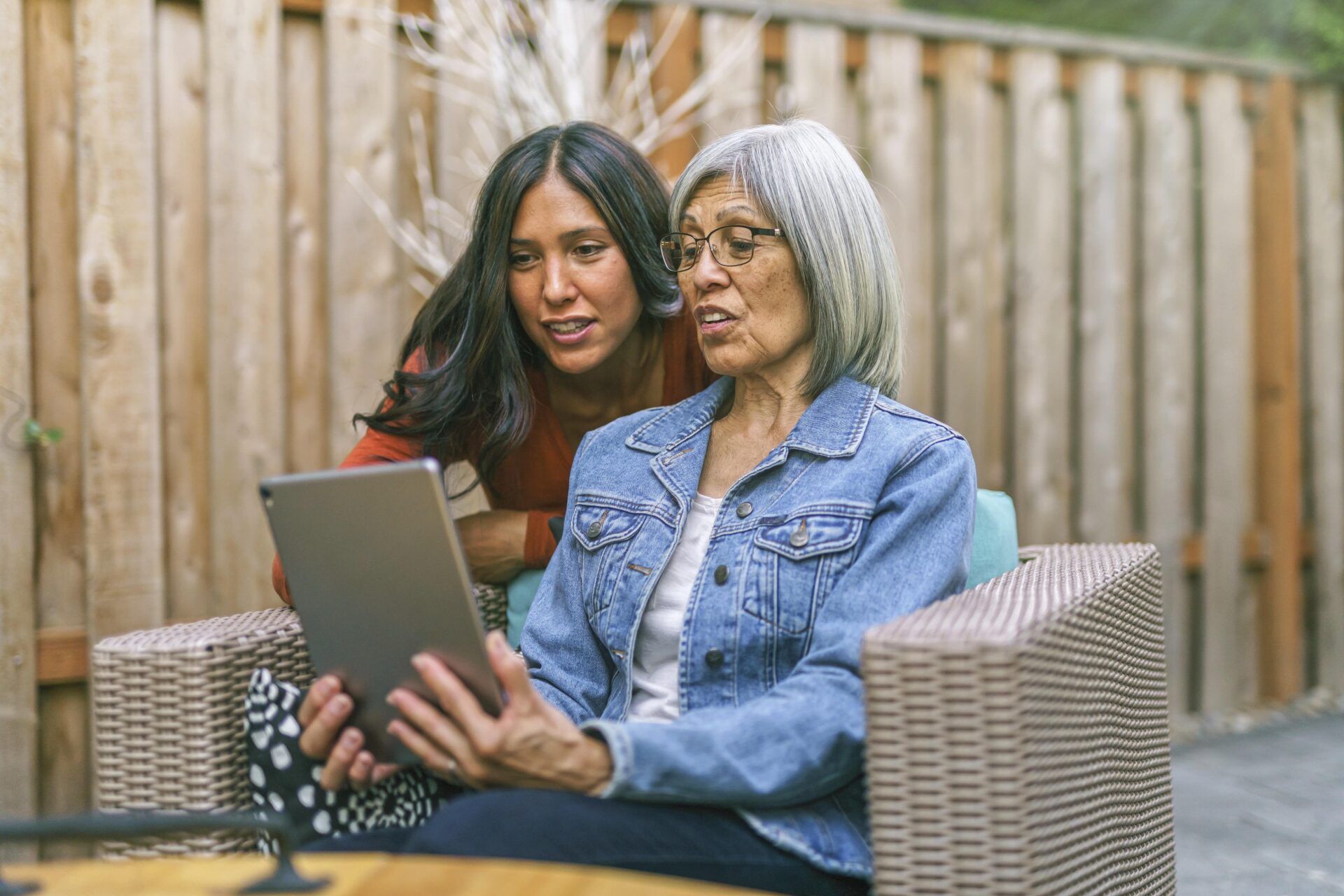 A young woman and an older woman looking at an Ipad together.