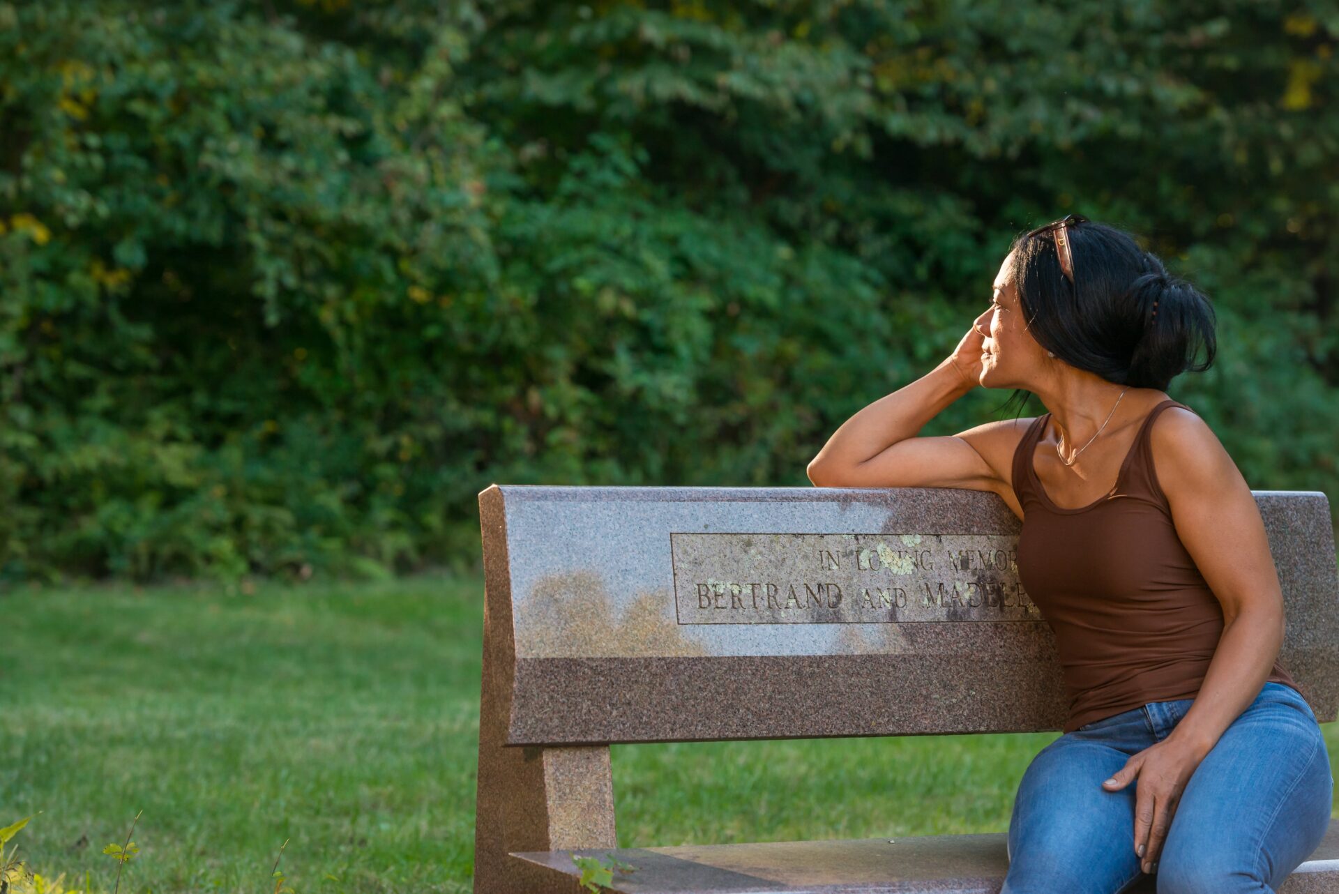 A young woman enjoying the nature on a memorial bench at the Ridge Recovery Center in Windham, CT.